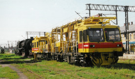 Nowoczesny pociąg pogotowia sieciowego serii WM 15P.M-05. w tyle parowóz...